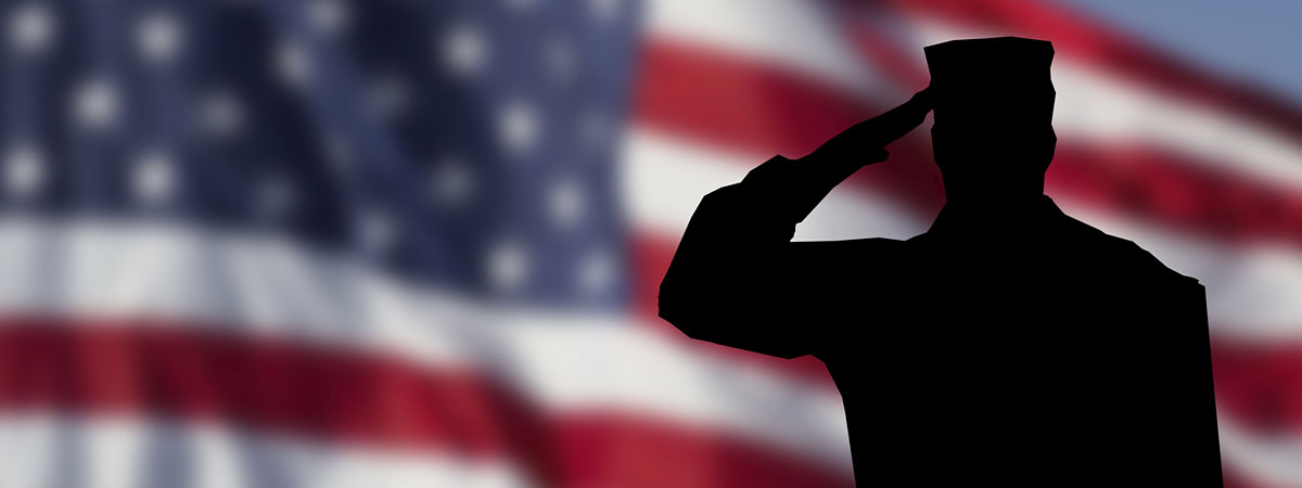 American flag in the background with silhouette of a soldier saluting the flag in the foreground