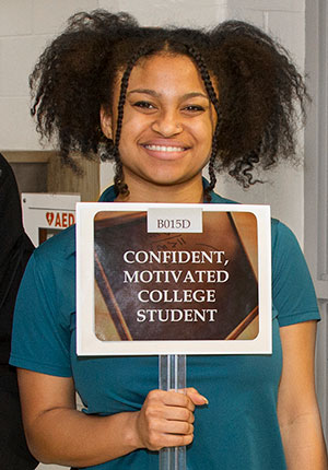 Female African-American student holding up a sign that says 