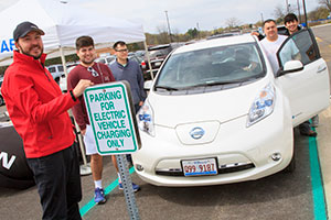 CLC students at the Electronic Vehicle Charging Station with an EV